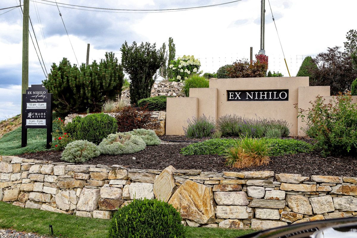 front view of ex nihilo winery sign with green lush grass