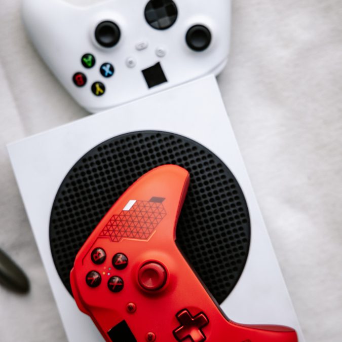 red and white xbox controllers sitting on a white xbox