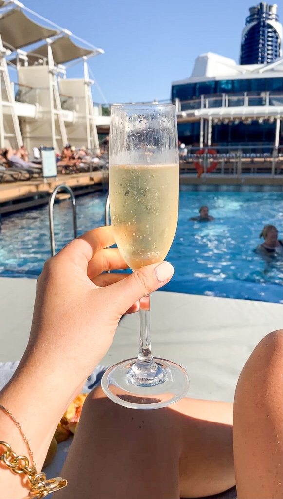 front view of champagne glass with prosecco by the pool
