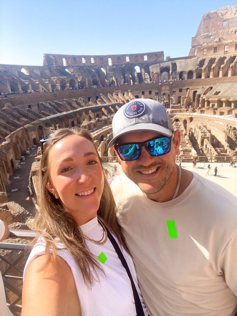 two people taking a photo in front of the colosseum in rome italy