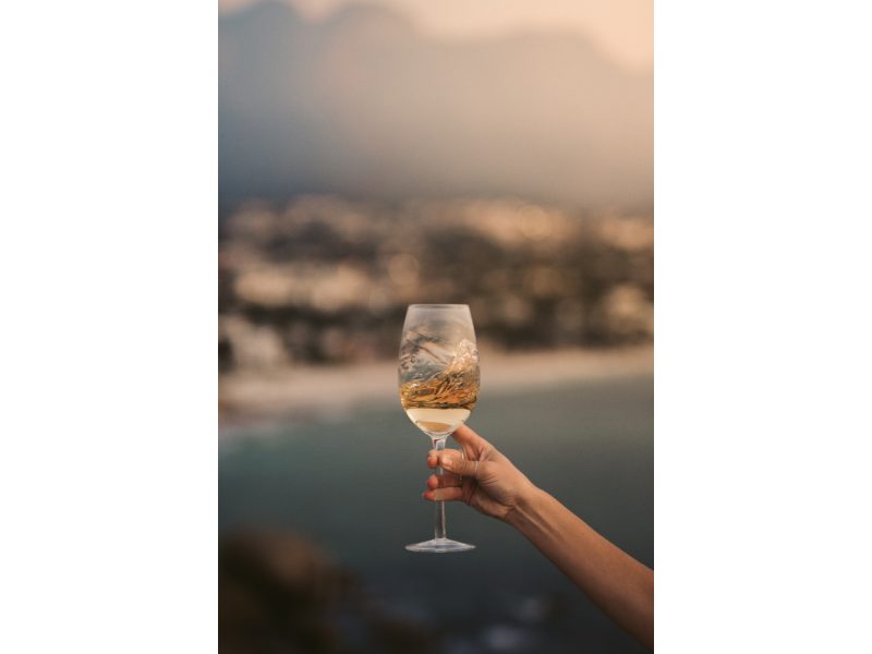 shot of glass of white wine with blurred out background of the lake