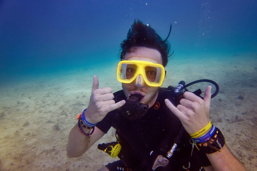 man scuba diving with yellow mask 