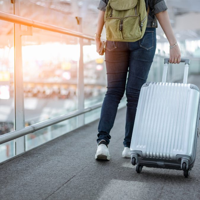 woman walking with grey suitcase at airport Carry-On & Checked Luggage Size In Cm