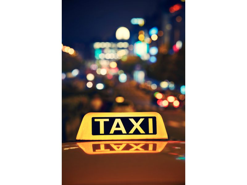 shot of taxi with city lights in background