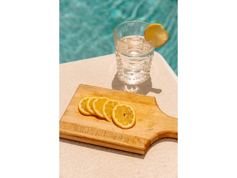shot of lemon water near the pool with lemon slices