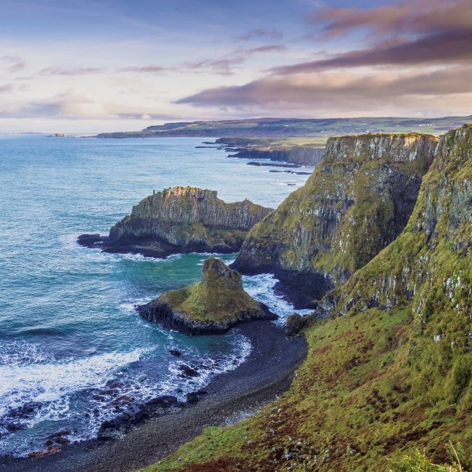 coastline of ireland with ocean on left and grassy mountains on right