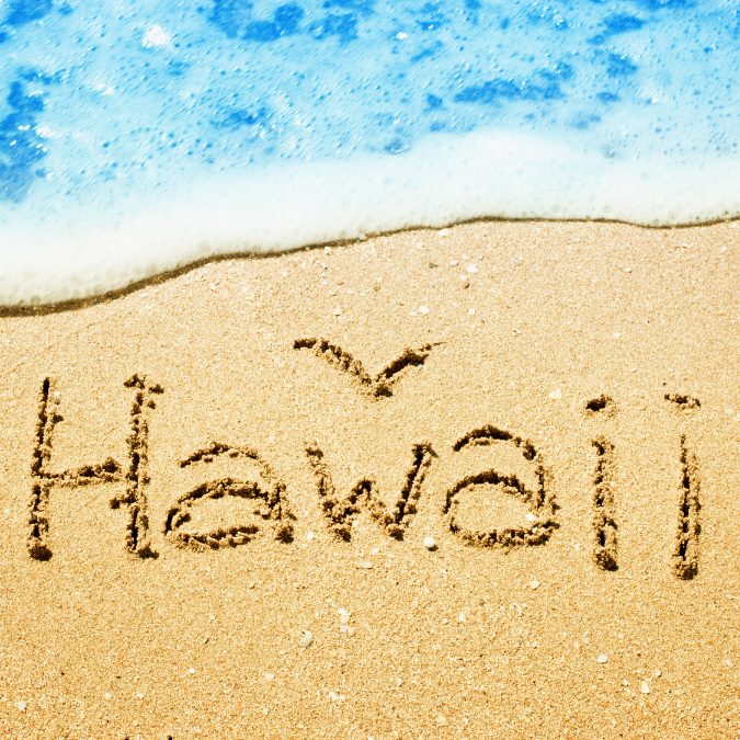 hawaii written in the sand with water