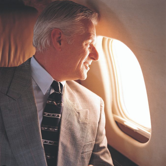 man on airplane looking out window