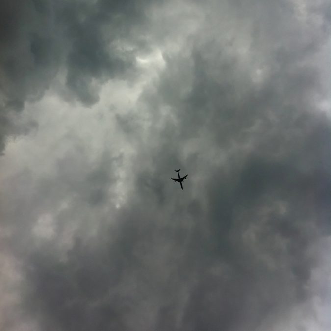 plane in the sky with a storm 