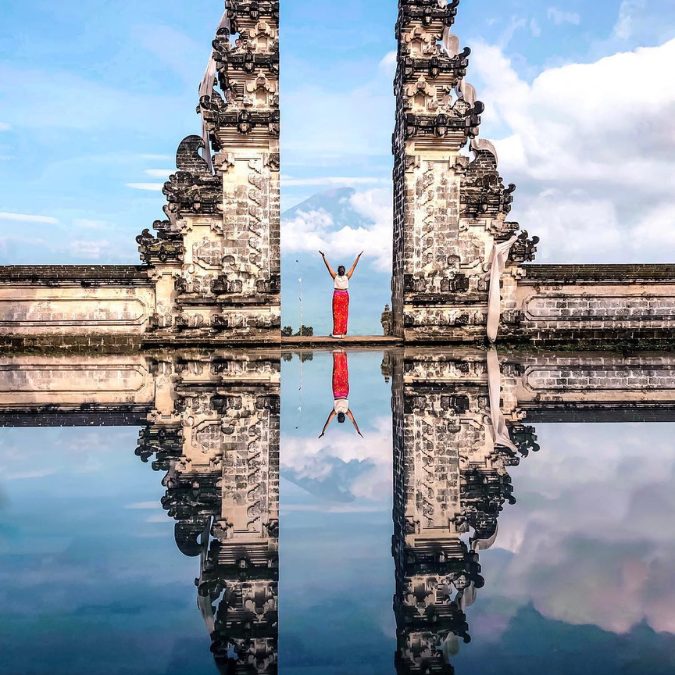 woman with red pants next to a balinese statue best time to visit bali 