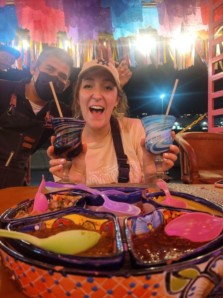 front facing view of girl holding two drinks with food in foreground