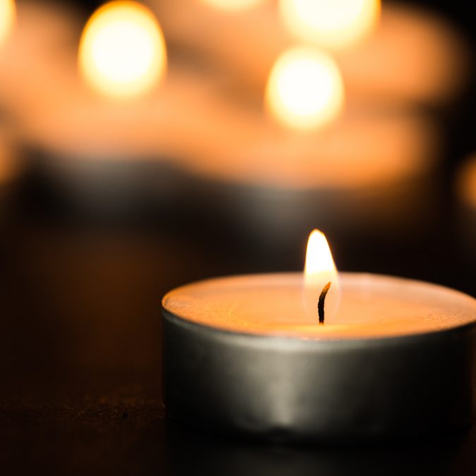 close up of a candle burning at a funeral 