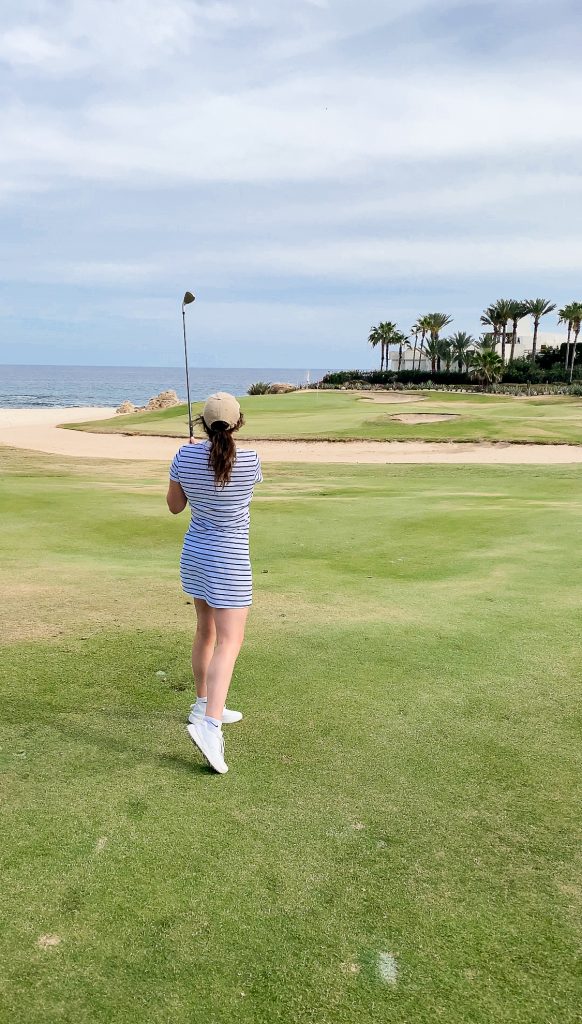 girl golfing with clean in background