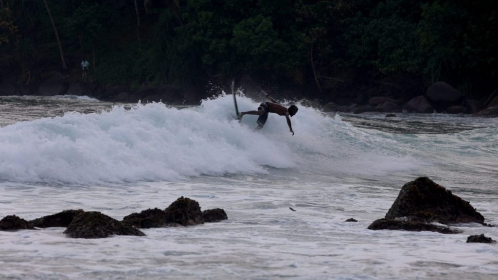 man surfing on a wave in mirissa sri lanka