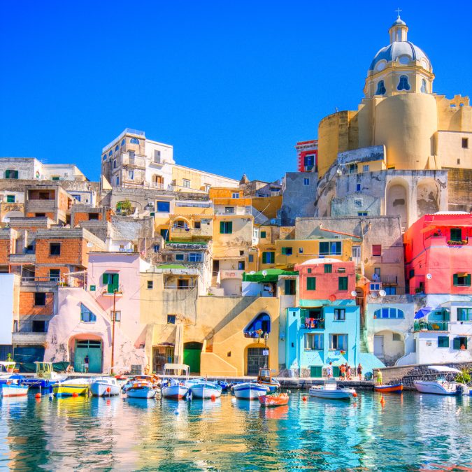 multi coloured buildings in italy on water with boats