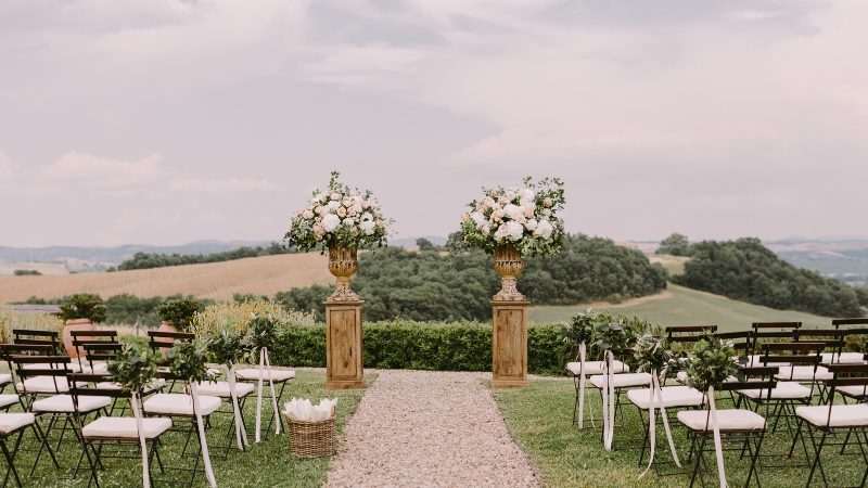 ceremony at an italian wedding with white chairs and flowers