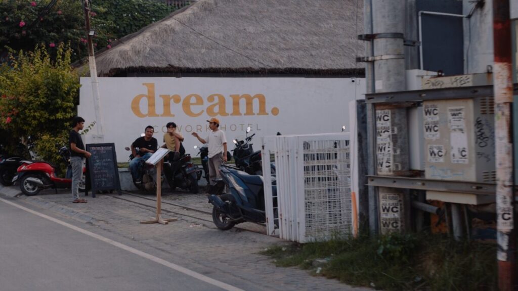 white wall that says dream with 4 men standing in front 